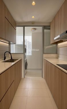 an empty kitchen with white tile flooring and wooden cabinets