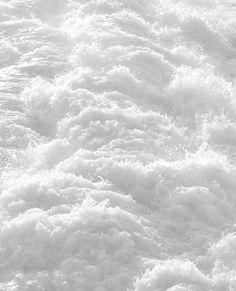 a person riding a surfboard on top of a wave in the ocean with white foam