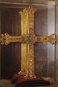 an ornate gold cross in a glass case