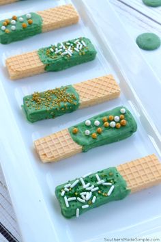 some waffles are decorated with green icing and sprinkles on them