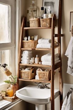 Wooden bathroom shelf holding towels, baskets, and toiletries above a white sink next to a foggy window. Toilet Cabinet Organization, Over The Toilet Storage Ideas For Towels, Smart Bathroom Storage, Small Bathroom Cabinet Ideas Storage, Bathroom Standing Shelf, Small Apartment Storage Solutions, Bathroom Storage Decor, Bathroom Storage Ideas For Small Spaces, Bathroom Towel Storage Ideas