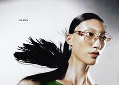 a woman wearing glasses with her hair blowing in the wind and text prada on it