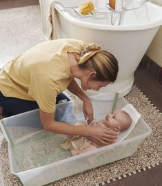 a woman holding a baby in a bath tub