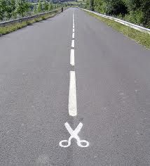 a pair of scissors drawn in the middle of an empty road