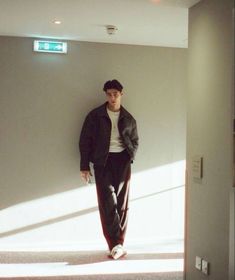 a young man is standing in the hallway