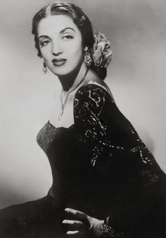 an old black and white photo of a woman wearing a dress with sequins on it