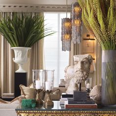 a living room filled with lots of furniture and plants in vases on top of a table