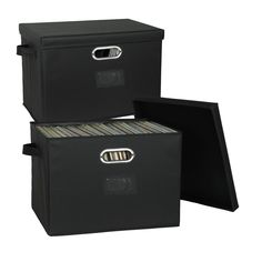 two black filing boxes with handles and drawers on each side, one has a file folder in the middle