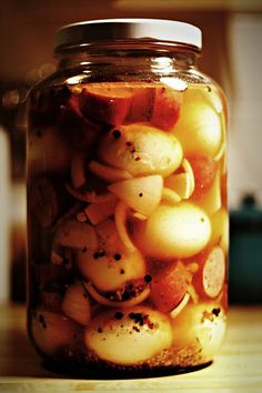 a jar filled with lots of food on top of a wooden table