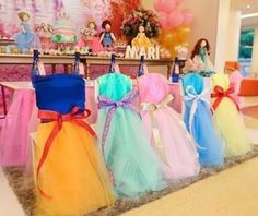 there are many dresses on display in this room with balloons and toys behind the table