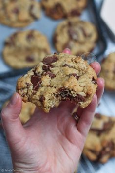 a hand holding up a chocolate chip cookie