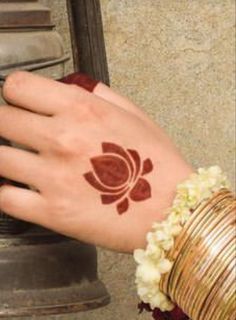 a woman's hand with a henna on it and a bell in the background