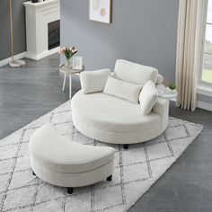 a living room filled with furniture and a large white ottoman on top of a rug