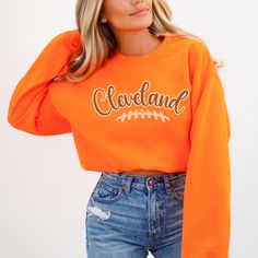 The Cleveland Football Sweatshirt for women is perfect GameDay apparel, offering a stylish way to show team spirit. This sweatshirt makes a great gift for a sport fan and is an ideal outfit idea for tailgate accessories for any girl. ✨ DETAILS ✨ ☆ Gildan 18000 unisex sweatshirt ☆ 50% Cotton (100% ethically grown in the US); 50% polyester ☆ Without side seams: Knit in one piece using tubular knit ☆ Ribbed knit collar with seam: Tightly elastic and retains shape effectively ✨ CARE INSTRUCTOINS ✨ ☆ Machine wash: cold (max 30oC or 90oF) ☆ Use non-chlorine bleach as needed ☆ Tumble dry on low heat ☆ Do not iron ☆ Do not dry clean  ✨ YOU MIGHT ALSO LIKE ✨ 📌 https://www.etsy.com/listing/1636664031/cleveland-football-sweatshirt-gift-for 📌 https://www.etsy.com/listing/1653514695/custom-team-footb Sporty Orange Sweatshirt With Letter Print, Orange Team Spirit Tops For Sports Events, Orange Tops For Game Day With School Spirit, Orange Tops For Sports Events With Team Spirit, Team-colored Fall Sports Sweatshirt, Team-colored Sweatshirt For Sports In Fall, Orange Crew Neck Top For Sports Season, Collegiate Orange Tops For Game Day, Varsity Crew Top For Fan Gear