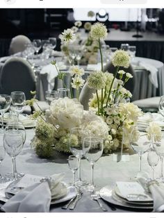 an image of a table setting with white flowers and place settings on the table top