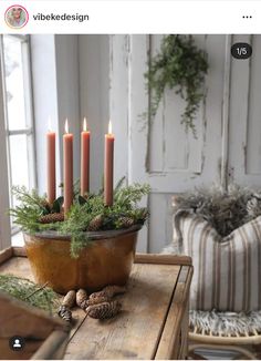 a wooden table topped with a potted plant and lots of candles next to a window