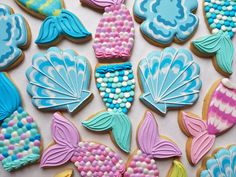 decorated cookies with mermaid tails and pearls on them, in the shape of seashells