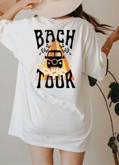 a woman wearing a white t - shirt with the words back to tour printed on it