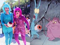 two women dressed in costumes standing next to each other on a sidewalk with cartoon characters behind them