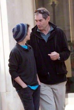 an older man talking to a young boy on the sidewalk