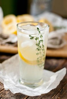 a glass filled with lemonade sitting on top of a wooden table