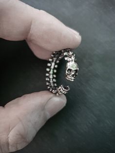 This unisex adjustable skull ring is a versatile and stylish piece of jewelry that is perfect for anyone who loves the skull theme. Its subtle design makes it an ideal choice for stacking with other rings, allowing you to create a unique and personalized look. The adjustable feature of this ring ensures that it can be worn by people of all finger sizes, making it an ideal choice for couples who want to share a similar style. Whether you're looking for a simple accessory to complement your everyd Adjustable Silver Skull Ring Punk Style, Adjustable Black Skull Ring, Engagement Ring Couple, Adjustable Metal Skull Ring Punk Style, Adjustable Stainless Steel Skull Ring, Promise Ring For Men, Hand-cast Black Skull Ring In Sterling Silver, Ring Couple, Engagement Rings Couple