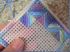 someone is stitching something with yarn on the floor and it looks like they are weaving