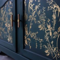 a blue cabinet with gold flowers painted on it