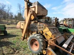 an old tractor is parked in the grass