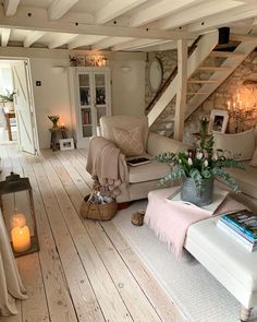 a living room filled with furniture and a fire place next to a staircase leading up to the second floor