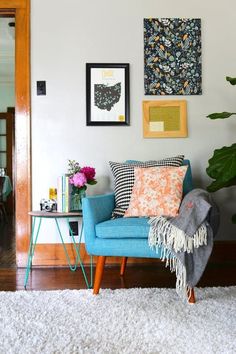 a living room filled with lots of furniture next to a wall mounted art on the wall