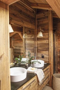 a bathroom with two sinks and wooden walls