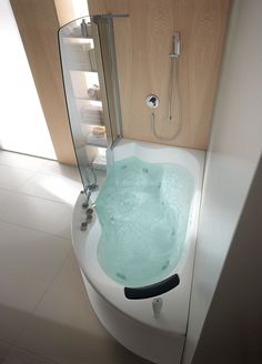 a bathroom with a tub and shower head mounted to the side of the bathtub