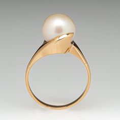 This elegant ring is centered with one (1) fresh water pearl and is set into a gold swirl. The ring is crafted in 14k yellow gold and currently a size 7. Elegant Yellow Gold Solitaire Pearl Ring, Formal Solitaire Pearl Ring In Yellow Gold, Formal Yellow Gold Solitaire Pearl Ring, Timeless Yellow Gold Akoya Pearl Ring, Elegant Yellow Gold Ring With Akoya Pearl, Elegant Yellow Gold Ring With Pearl Drop, Elegant Oval Bypass Ring For Formal Occasions, Elegant Yellow Gold Rings With Pearl Drop, Elegant Yellow Gold Pearl Drop Ring