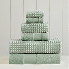 four towels stacked on top of each other in green and white checkered pattern,