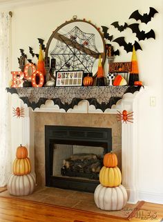 a fireplace decorated for halloween with pumpkins, bats and other decorations on the mantle