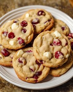 a white plate topped with cookies covered in cranberries and marshmallows