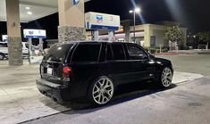 a black suv parked in front of a gas station