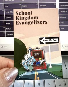 someone holding up a sticker that reads school kingdom evangelizerrs best life ever