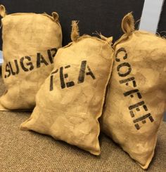 three burlap bags filled with coffee beans sitting on top of a carpeted floor