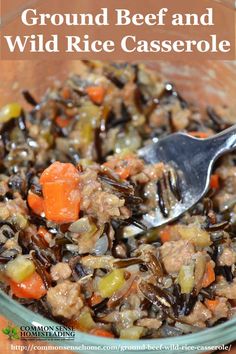 ground beef and wild rice casserole in a glass bowl with a spoon