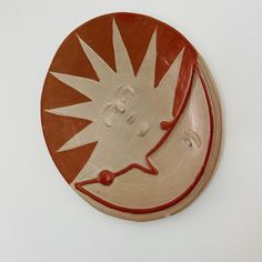 a red and white plate with an image of a bird on it's side