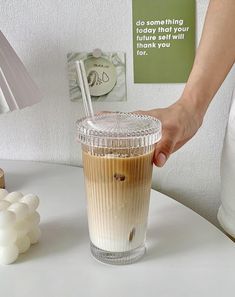 a person is holding a straw in a cup