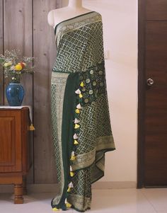 A spectacular Handwoven Deep Green Pure Banarasi Handloom Khaddi Georgette Bandhani Saree in gorgeous pattern. Its a fusion of karigari of Banarasi and Gujarati. Additional Information Color : Green Technique: Bandhani is a tye & dye technique in which fabric is pinched with nails and tied with thread and then dyed to create fabulous patterns. Fabric: Pure Georgette Blouse Piece: Included Since this product is handwoven, there might be slight irregularities. But doesn't that add to the singu Green Banarasi Silk Choli With Traditional Patterns, Designer Pre-draped Saree For Diwali With Traditional Patterns, Green Brocade Traditional Wear With Zari Weaving, Designer Bandhani Print Art Silk Saree, Designer Art Silk Saree With Bandhani Print, Designer Pre-draped Saree With Traditional Patterns For Navratri, Navratri Traditional Wear With Bandhani Print, Bohemian Cutdana Dupatta For Designer Wear, Pre-draped Saree With Traditional Patterns For Transitional Season