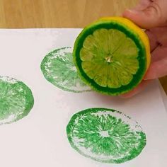 a hand is holding a lemon and stamping on paper