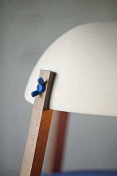 a close up of a chair with a wooden leg and blue plastic knobs on it