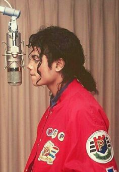 michael jackson in front of a microphone with patches on his jacket