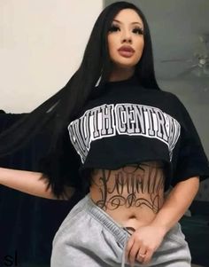 a woman with long black hair and tattoos on her stomach, wearing grey sweatpants