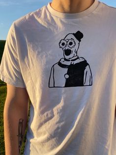 a man wearing a t - shirt with an image of a clown on it's chest