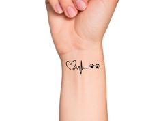 a woman's wrist with a heart and paw prints on the wrist, showing her heartbeat